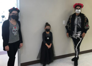 Staff (left and right) and a student (center) dressed up for the Day of the Dead